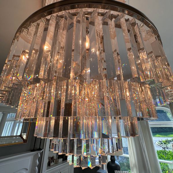 Elegant crystal chandelier with multiple hanging prisms illuminating a room.