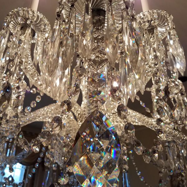 Close-up of a sparkling crystal chandelier with lit candles.