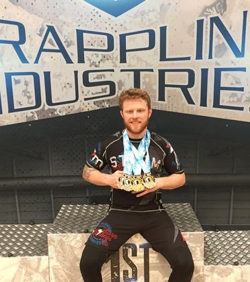 Athlete posing with multiple gold medals on a podium.