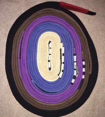 Oval-shaped multicolored braided rug on a carpet.