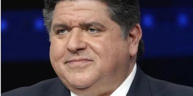 A man in a suit with a serious expression against a blue background.