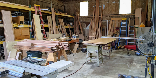 RaJaM's fully operational Mill Shop, featuring table saws, wood, and other machinery.