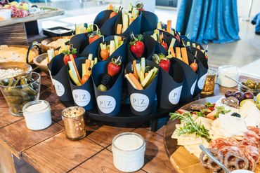 Elegant snack cones with fresh fruits and veggies arranged on a table.