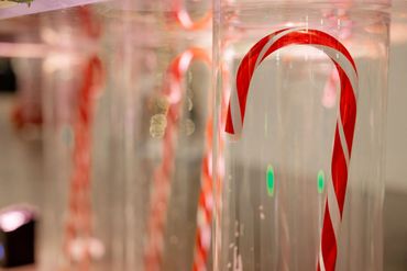 Close-up of candy canes hanging in a row, creating a festive holiday display.