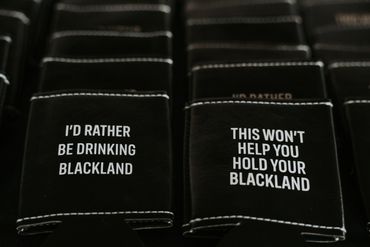 Black wallets with humorous texts about Blackland and holding Blackland.