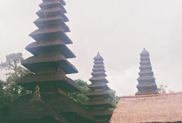 Traditional pagoda-style temple roofs under a cloudy sky.