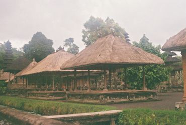 Traditional thatched roof pavilion in a lush garden.