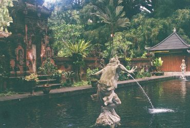 Garden pond with statues and lush greenery.