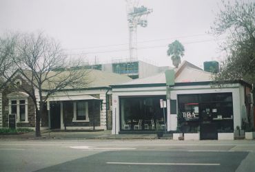 Old stone building with a modern cafe on a gray day.