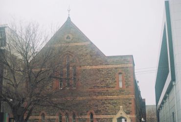 Historic stone church building on a cloudy day.