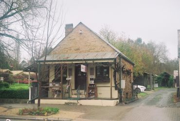 Small rustic roadside shop surrounded by trees.
