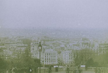 Foggy cityscape view with buildings and people.