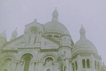 Historic church with domed towers under overcast sky.