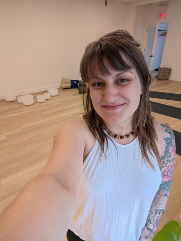 Young woman smiling in an indoor yoga studio.