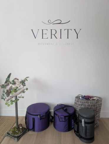 Movement and wellness studio corner with bags and plant.