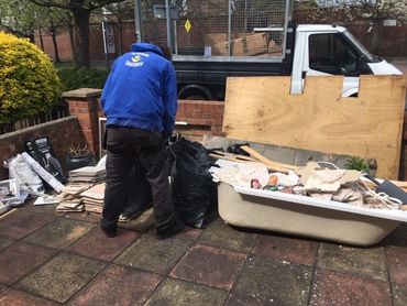 Bathroom Suite Rubbish Removal, In A Front Garden. Man Starting To Clear With Van In Back Ground.