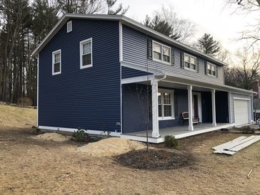A house with stone gray color walls and white windows