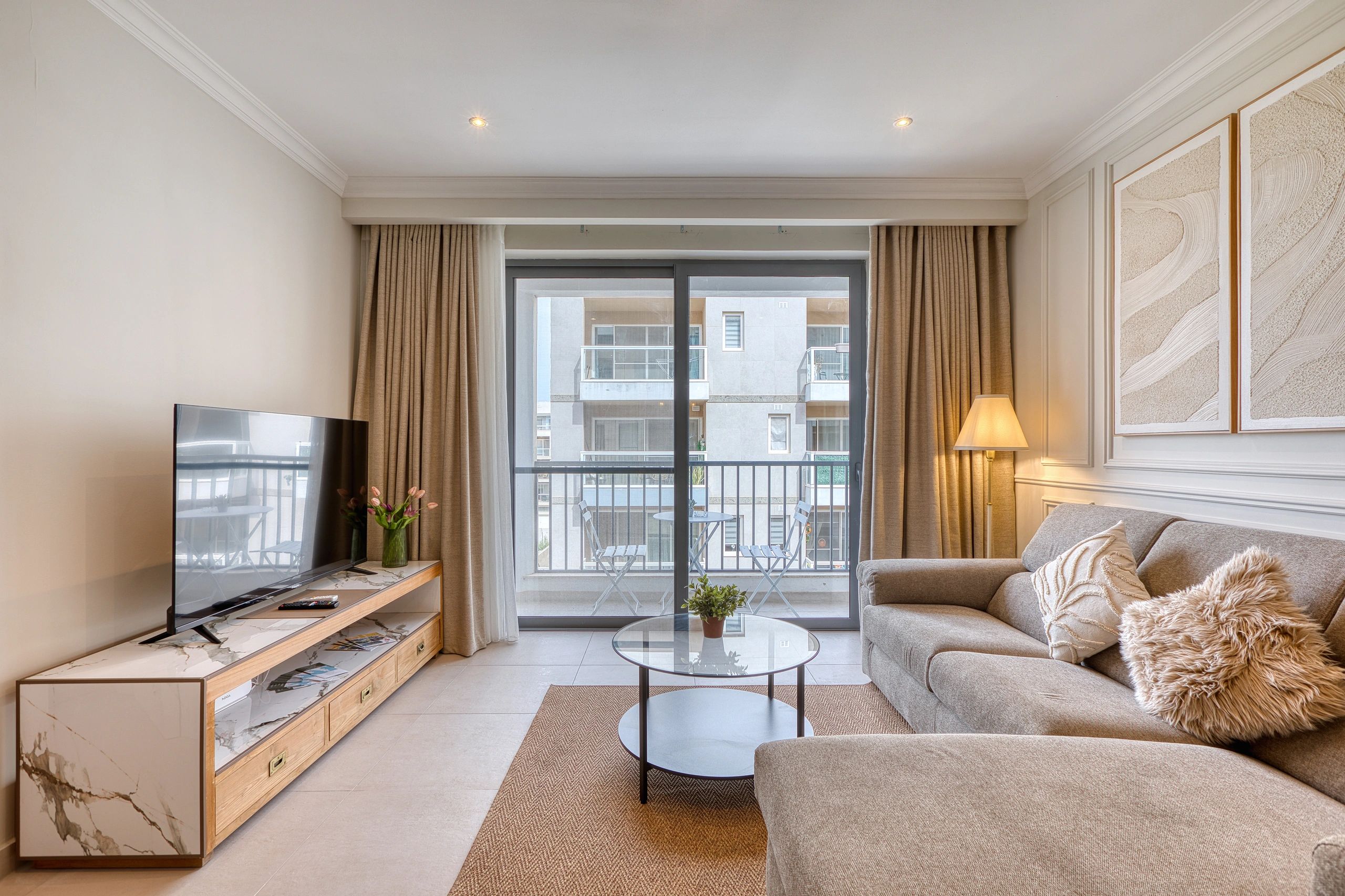 Cozy living room with a sofa, TV, and balcony view.