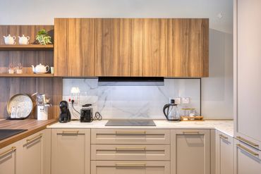 Modern kitchen with wooden cabinets, white countertop, and coffee appliances.