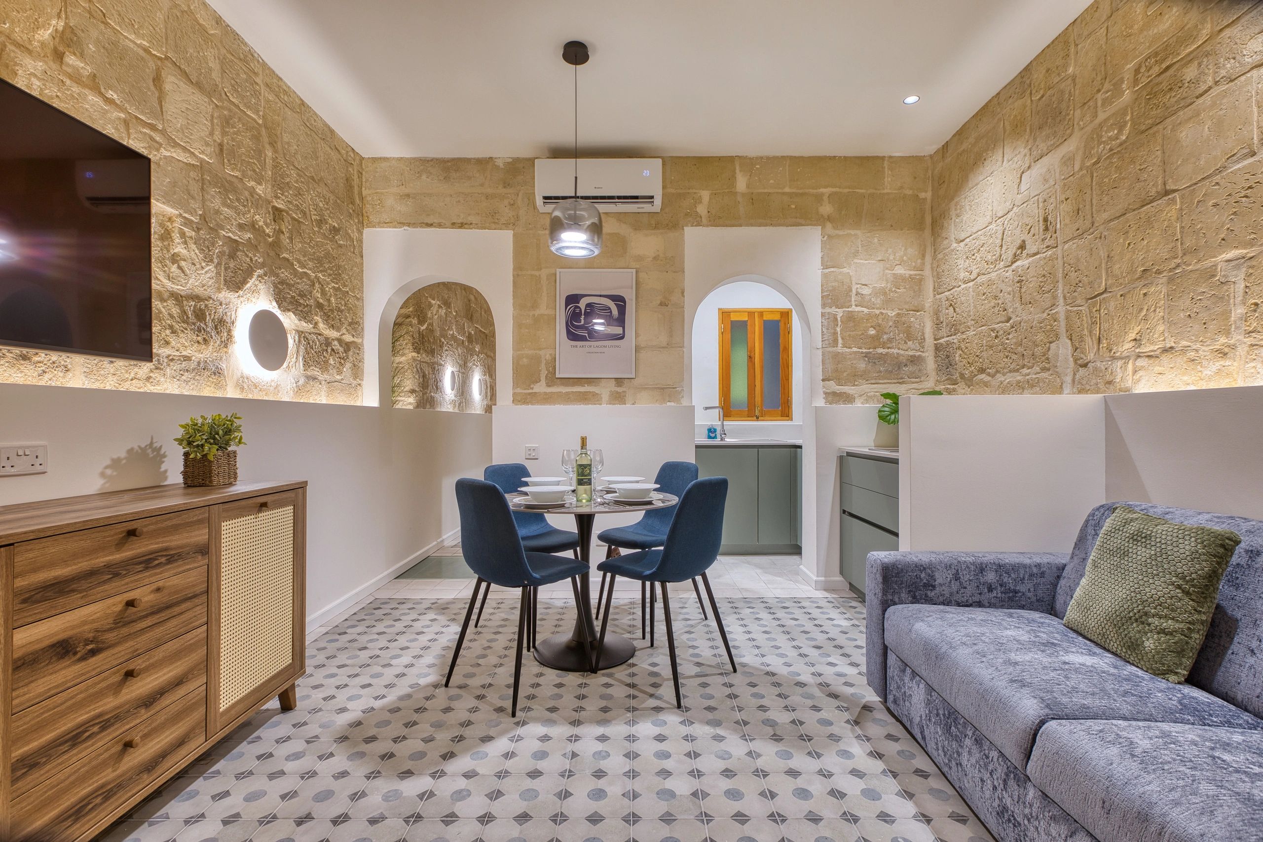 Cozy modern dining area with stone walls and patterned flooring.