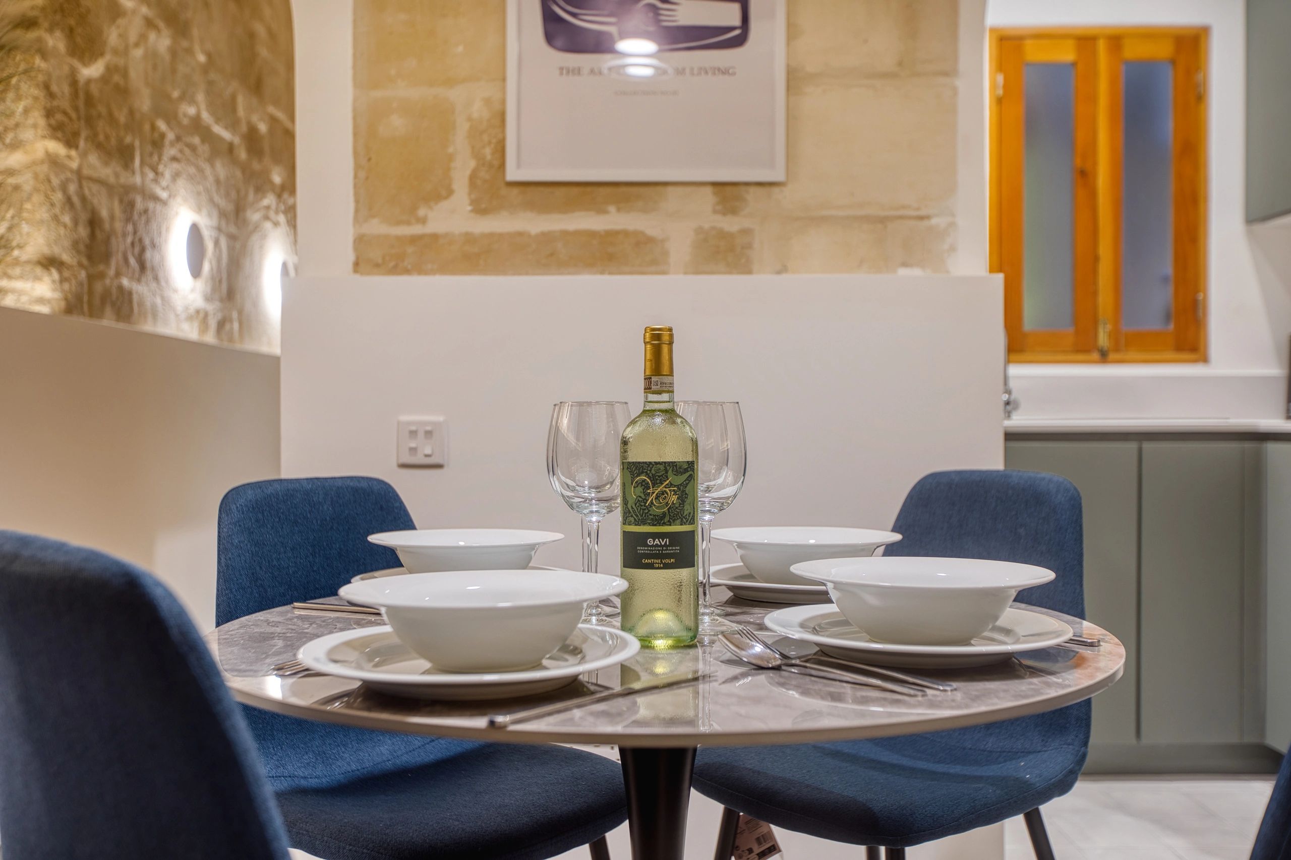 Elegant dining table set with wine and four place settings in a cozy room.