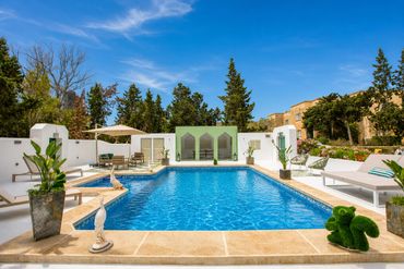 Elegant outdoor pool area with clear blue water and stylish lounge chairs.