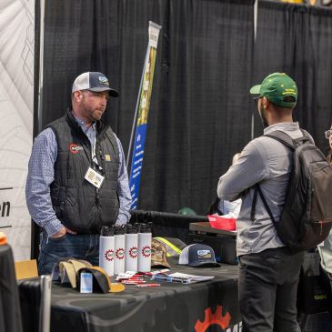Man presenting products at a trade show booth.
