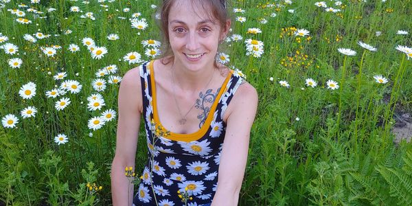 Smiling woman in daisy field.