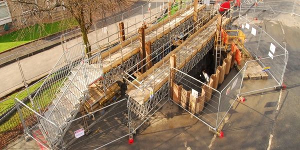 Bridge construction site with scaffolding and safety barriers on a road.