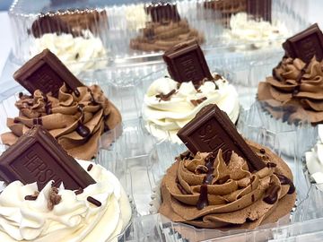 Cupcakes with chocolate and vanilla frosting topped with Hershey's chocolate pieces.