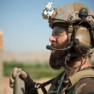 a army person holding microphone with headset