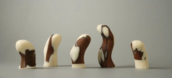Five abstract wooden sculptures with white and brown patterns on a neutral background.