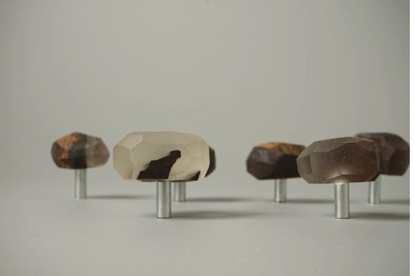 Faceted wooden knobs with metal bases arranged on a flat surface.
