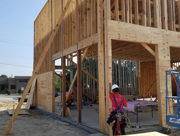 Construction workers building a wooden frame structure on site.