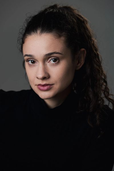 Retrato de mulher jovem com cabelo cacheado.