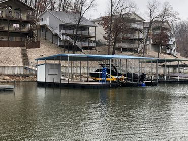 A two slip covered dock with boat lifts and a bar/storage shed.