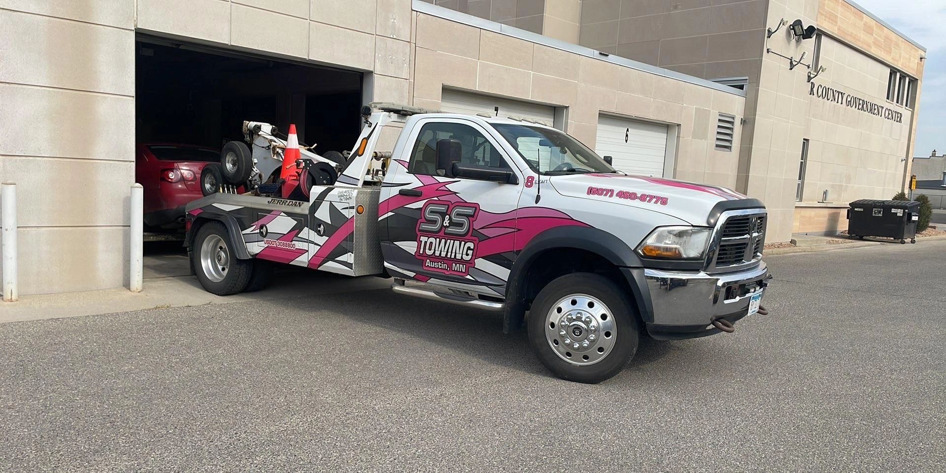 Wrecker #8 at the Mower County Law Enforcement Center with a vehicle on the hook.