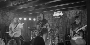 Black and white photo of a band performing on stage.