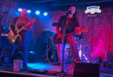 Band performing live on stage with colorful lights.