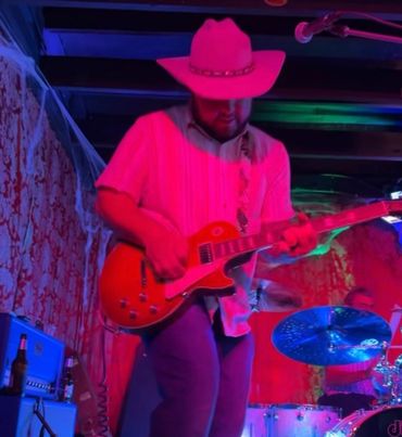 Gavin Carmichael shredding on his Gibson guitar on stage at the Sand Dollar with the Casual Suspects
