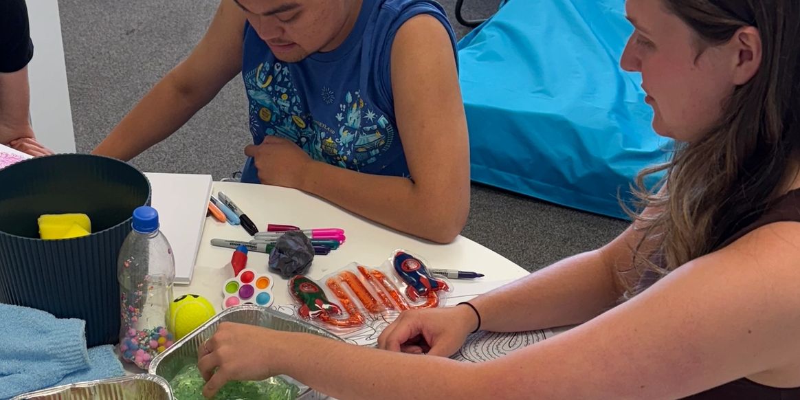 People engaged in a creative activity with art supplies on a table