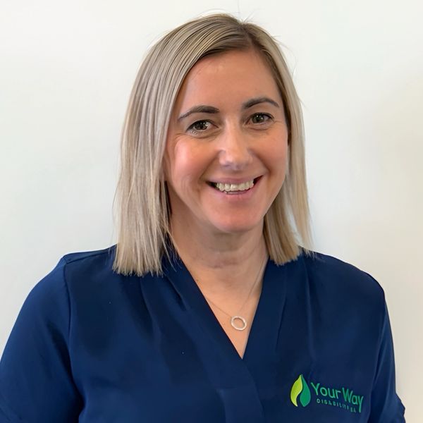 Smiling woman in a navy blue shirt with a company logo.