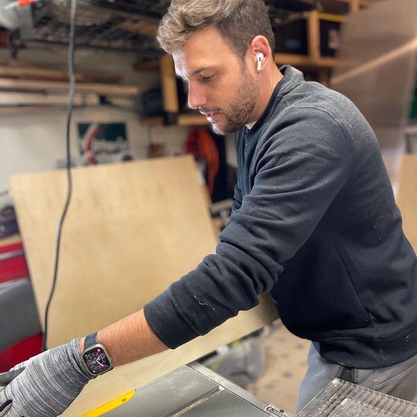 Owner of South Austin Handyman, Neto Zapparolli, cutting plywood in a workshop