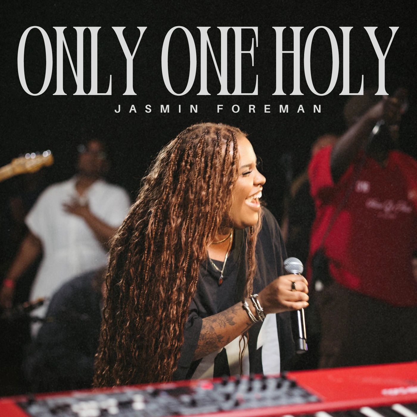 Jasmin Foreman passionately singing live with a joyful expression.