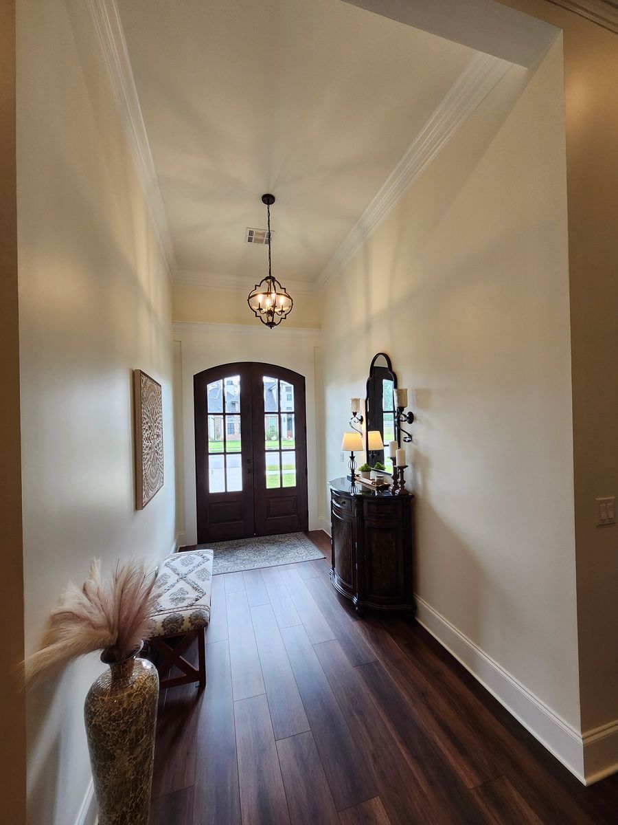 Entry hall with hardwood floors and arched wood doors