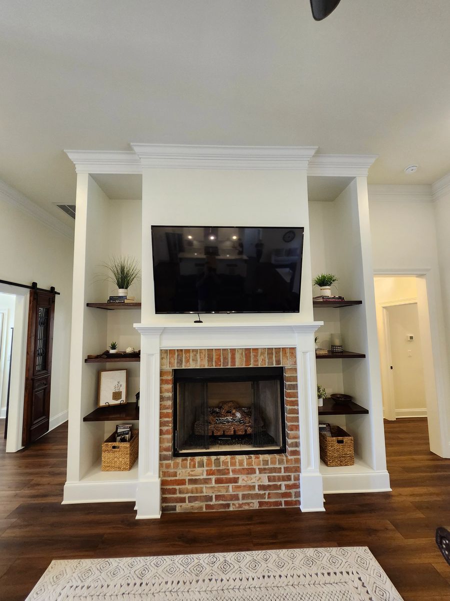 Living room with brick fireplace and built-in shelving