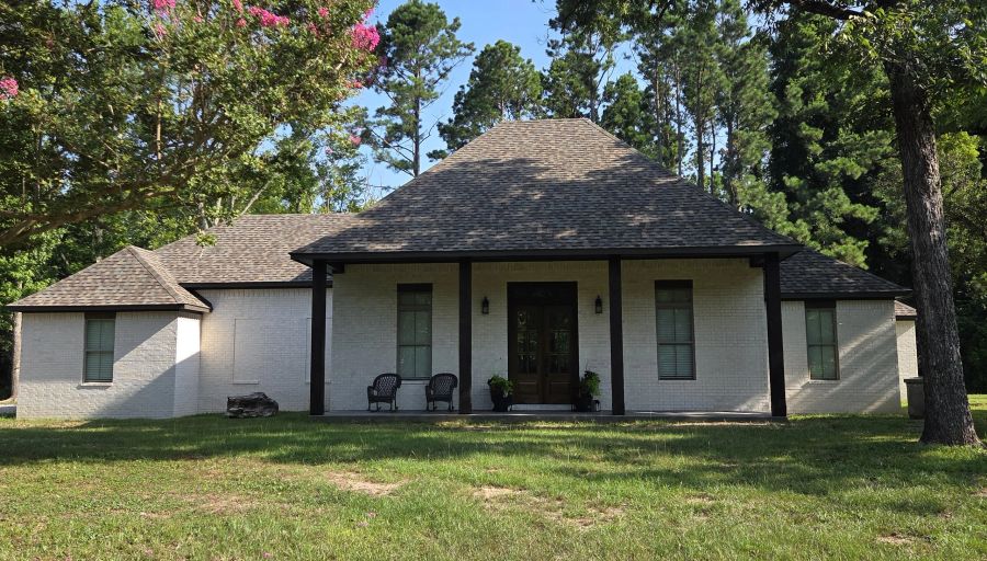 White brick Acadian home from the side