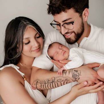 Happy parents holding their newborn baby.