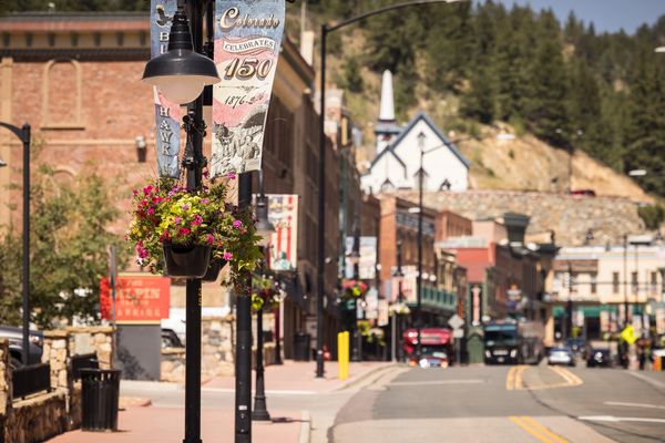 Quiet small town street with flowers and banners on lamp posts.