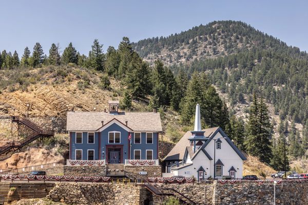 Mountain town school and church with forest background.